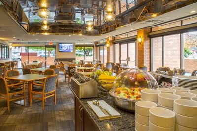 Dining area at Embassy Inn Victoria with a full breakfast buffet and several tables set for guests
