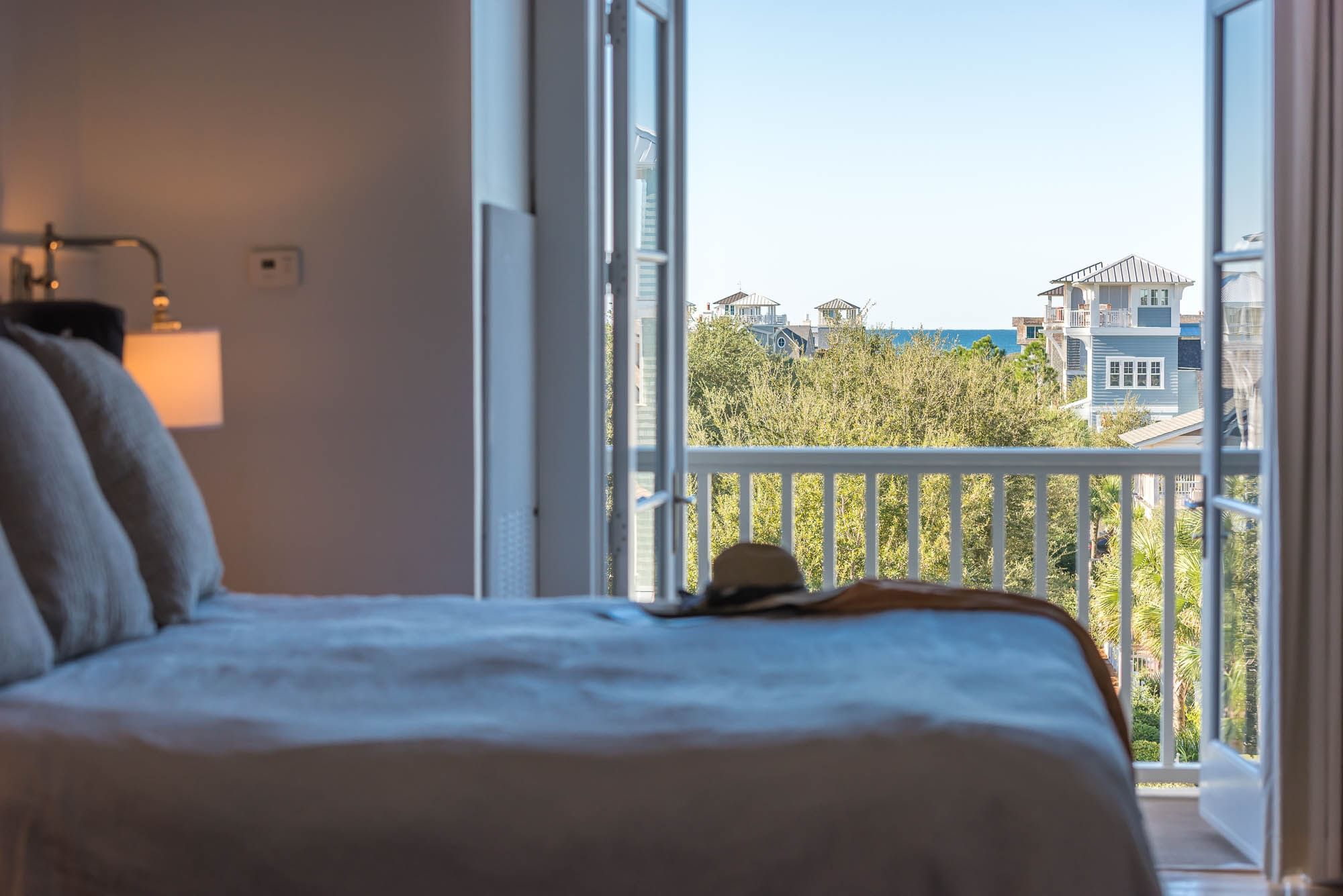 Cozy king bed and balcony view in Premium Resort Suite at Watersound Inn