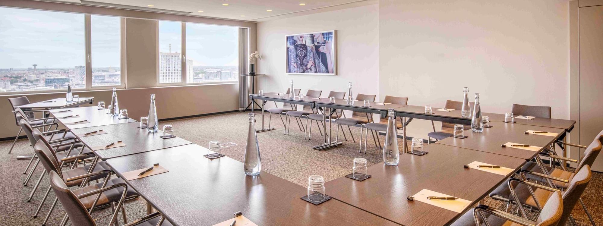 Meet 26 Three Meeting room with tables arranged in a U-shape, and chairs at The Hotel Brussels