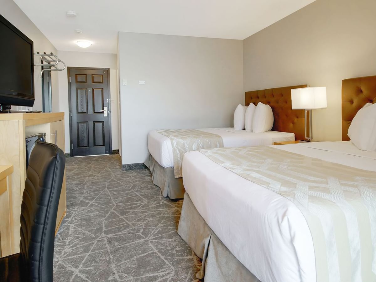 Inside view of the room with double beds, TV and desk.