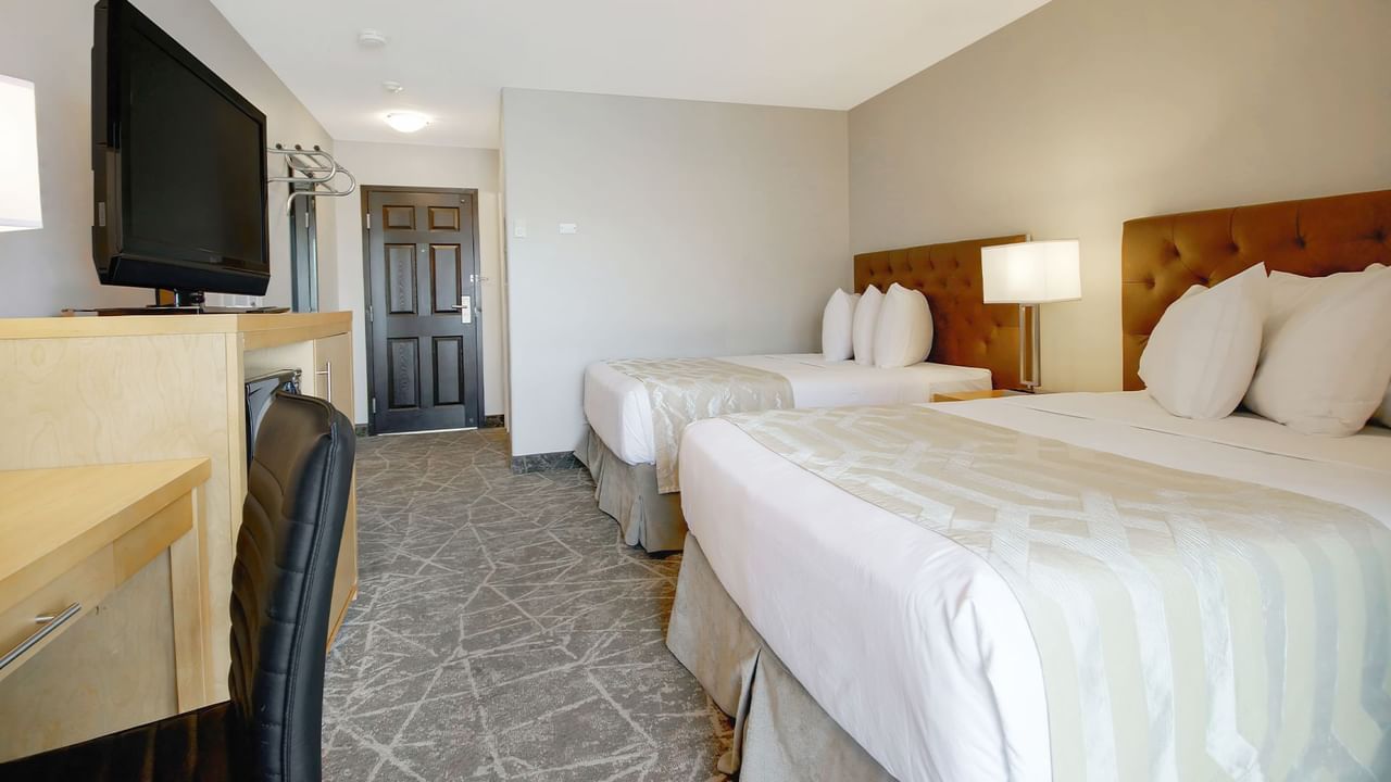 Inside view of the room with double beds, TV and desk.