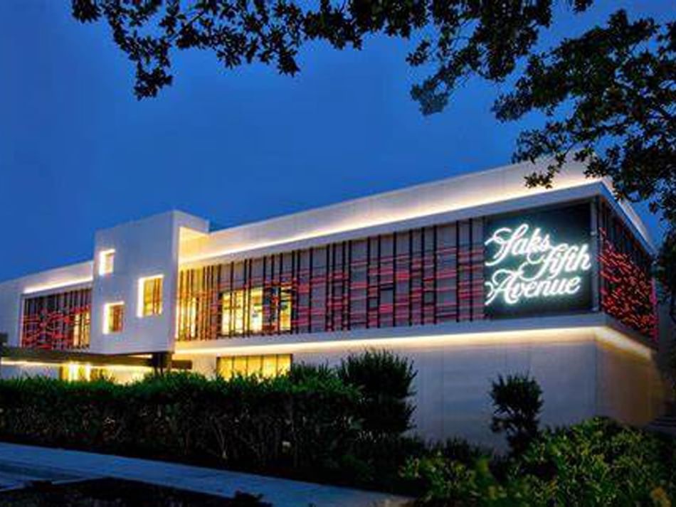 Saks Fifth Avenue storefront near Granduca Houston, illuminated at night with modern architecture and a stylish sign