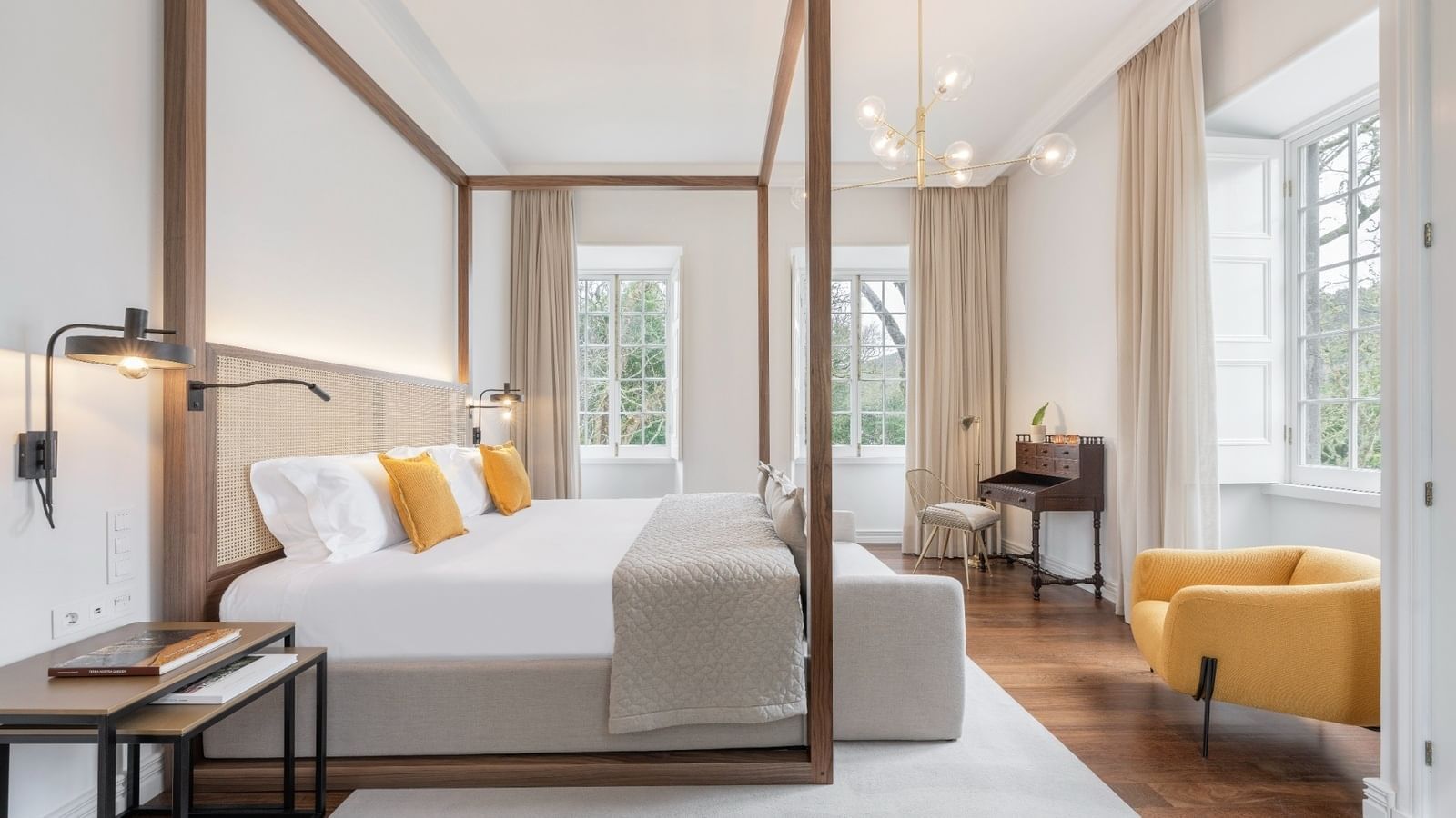 Florence canopy bed, comfy pillows, chandelier & work desk in a room at Bensaude Hotels