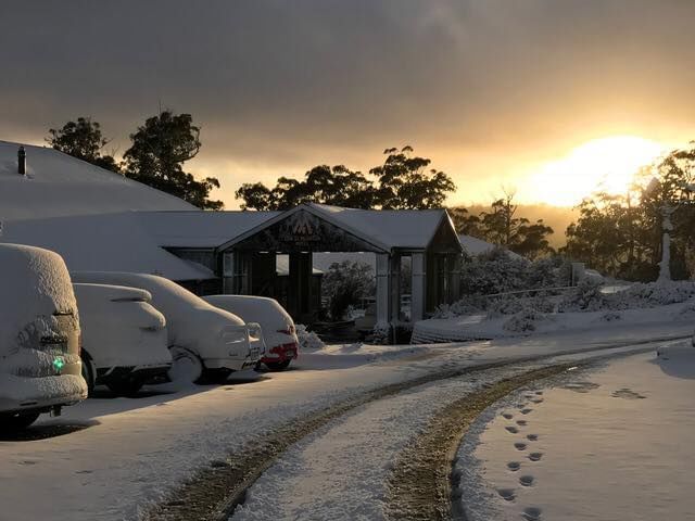 Hotel and vehicles covered with snow near Cradle Mountain Hotel
