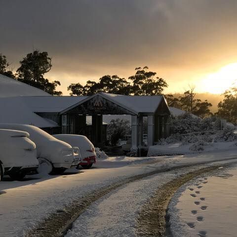 Hotel and vehicles covered with snow near Cradle Mountain Hotel