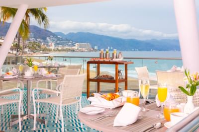 Beachfront dining setup with breakfast and ocean view at Villa Premiere Boutique Hotel & Romantic Getaway