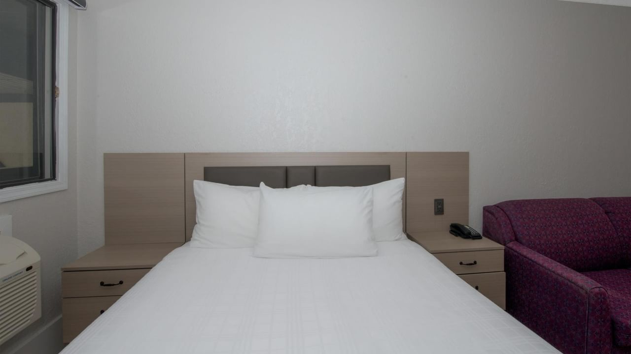 Queen bed in a guest room at Coast Red Deer Hotel