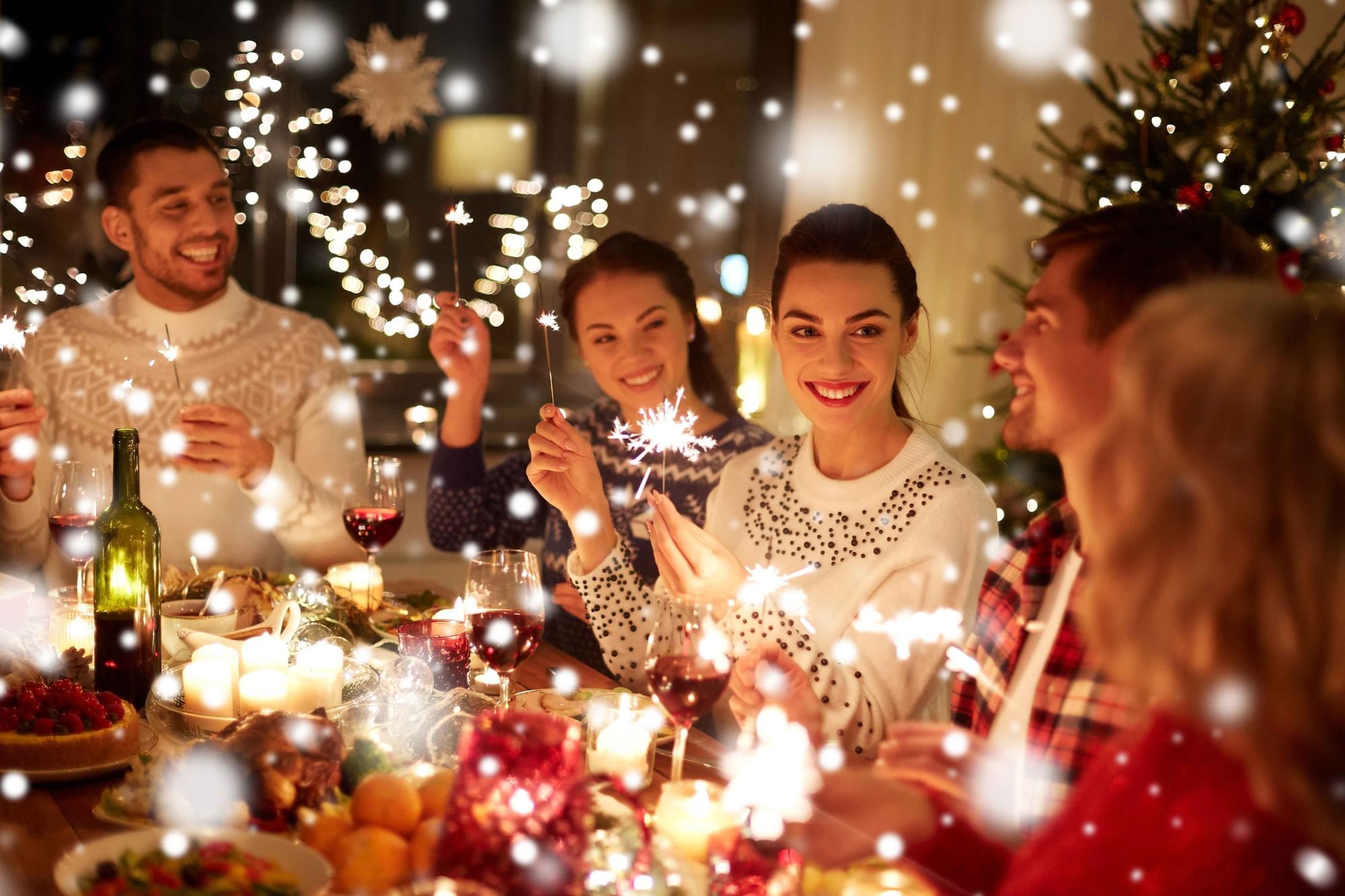 Festive gathering featuring friends holding sparklers, surrounded by elegant dining table at Cove Pocono Resorts