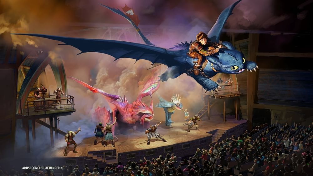 A conceptual rendering of a full audience watching Vikings and colorful dragons onstage while a boy in leather armor rides a black dragon over the audience.