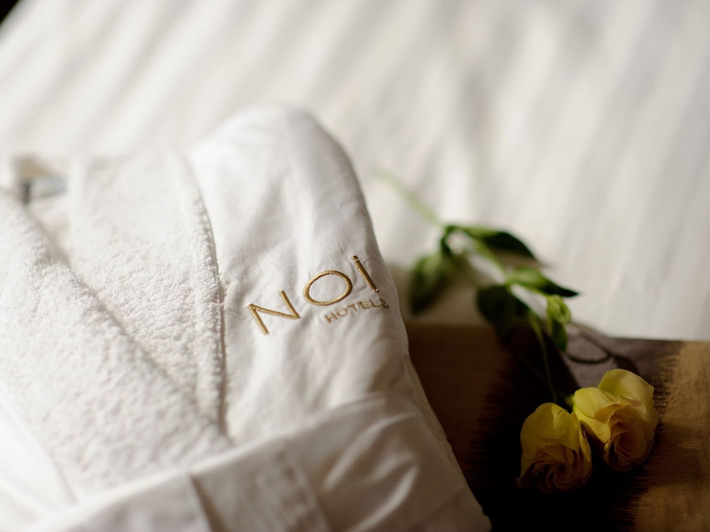 white bathrobe & 2 yellow roses at NOI Vitacura hotel         