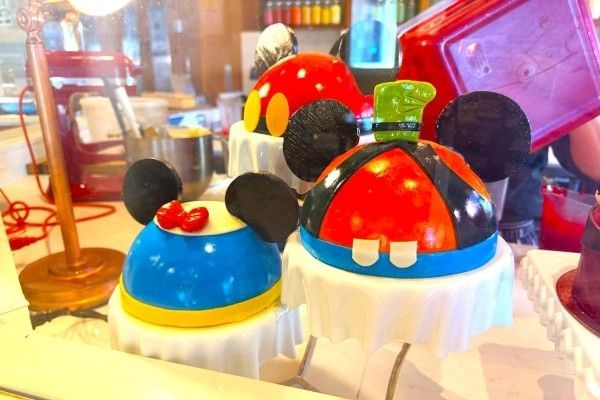 Glossy domed cakes reminiscent of Goofy and Donald Duck from Amorette's Patisserie at Disney Springs.
