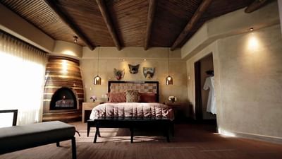 Luxurious Governor’s Suite bedroom at Hilton Santa Fe Buffalo Thunder featuring a cozy fireplace and artistic wall decor