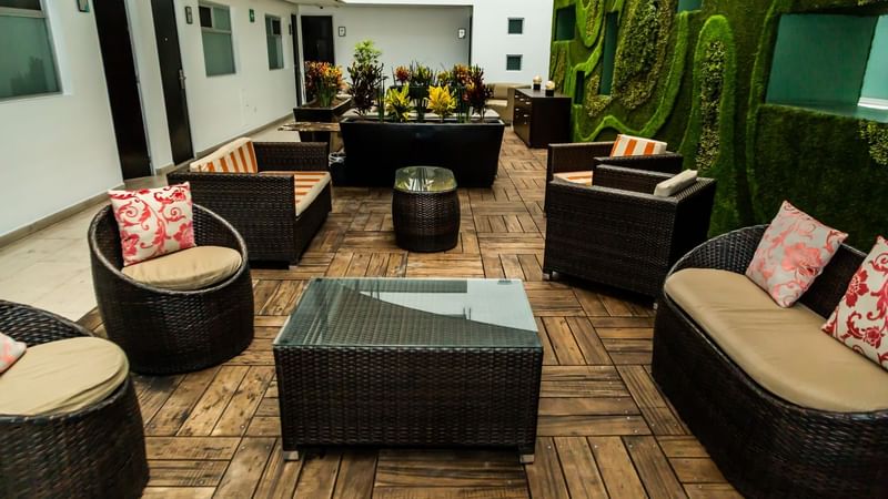 Lounge area with sofas, coffee tables, indoor plants & wooden floor at Gamma Hotels