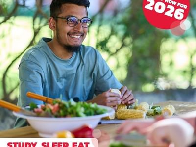 Man preparing food at a table with text: Apply now for 2026, Study. Sleep. Eat. On campus.
