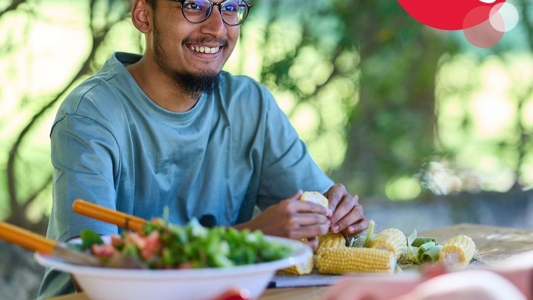 Man preparing food at a table with text: Apply now for 2026, Study. Sleep. Eat. On campus.