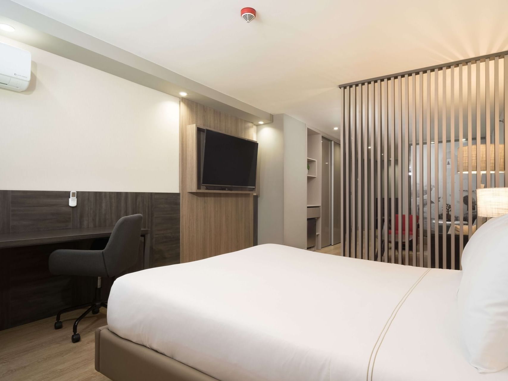 Work desk facing the bed in Deluxe Suite King with a separate TV lounge area at Habitel Prime Hotel