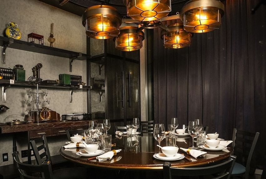 Dining area with round table and chairs under a modern chandelier at Paradox Vancouver