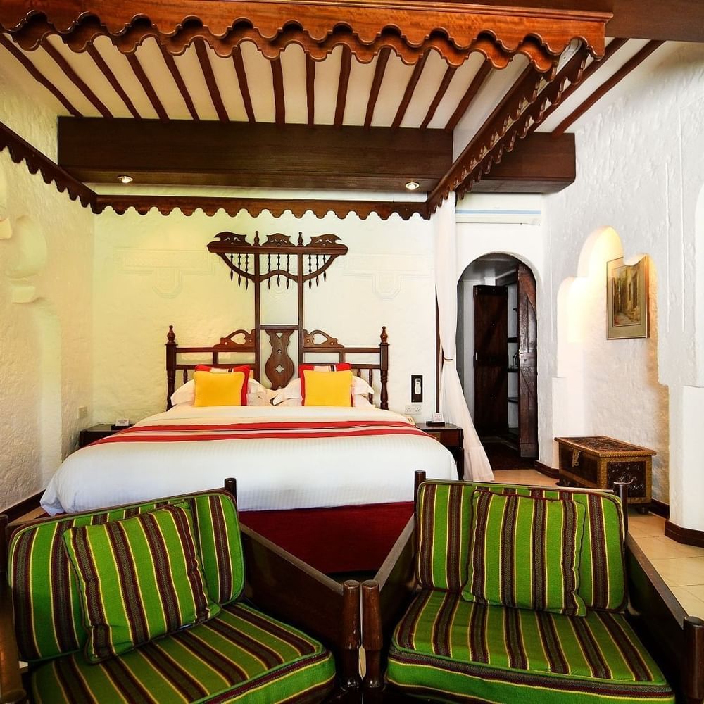Elegant Garden Suite room with large bed and chairs at Serena Beach Resort & Spa in Mombasa.
