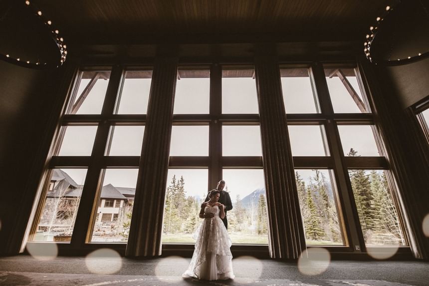 Newlywed posing by a large window at The Malcolm Hotel 