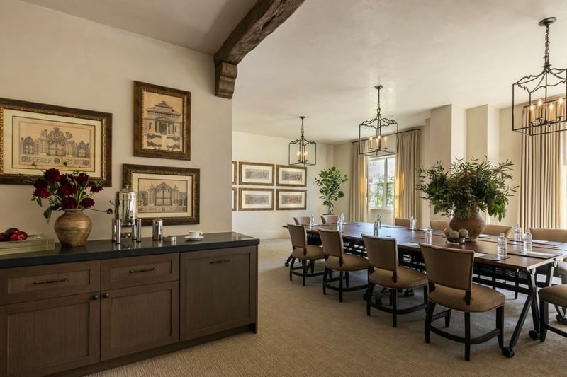 The Jessamine Room at Granduca Houston, with a long table, sleek lighting, wall art, and a side cabinet in a stylish setting