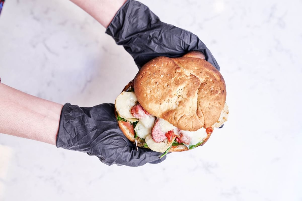 Close-up of a chef holding a Lachs-burger at Flemings Hotels