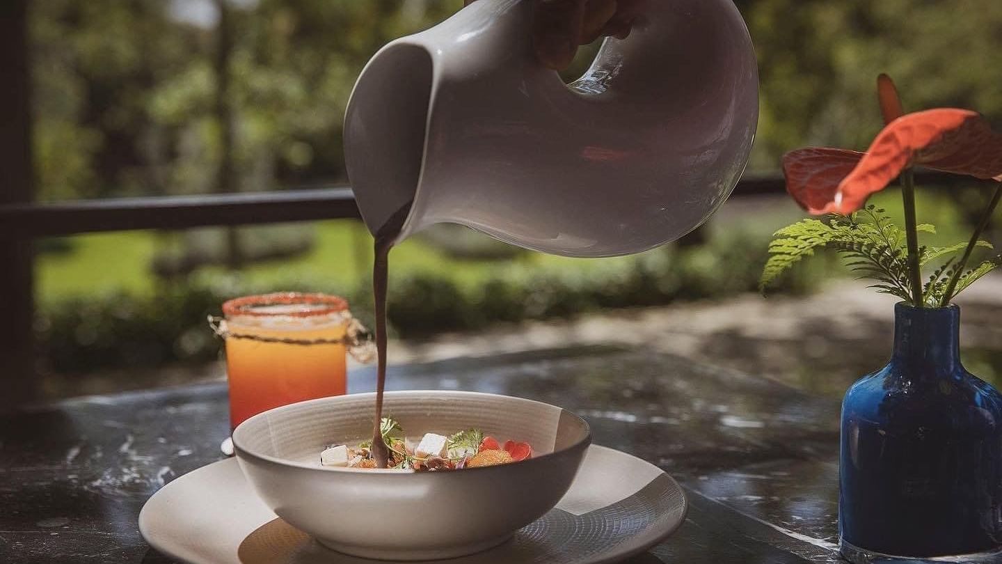 Fruit salad topped with chocolate syrup at Curamoria Collection