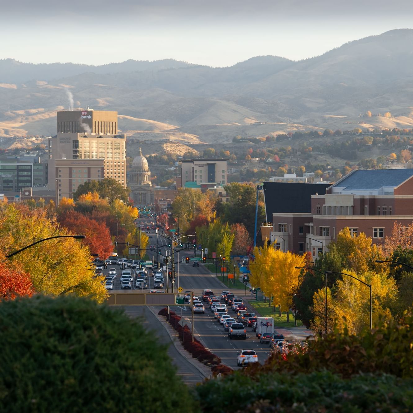 Cityscape with autumn foliage, traffic, and distant hills near Hotel 43