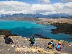 4 people sitting on a mountain slope near Singular Patagonia
