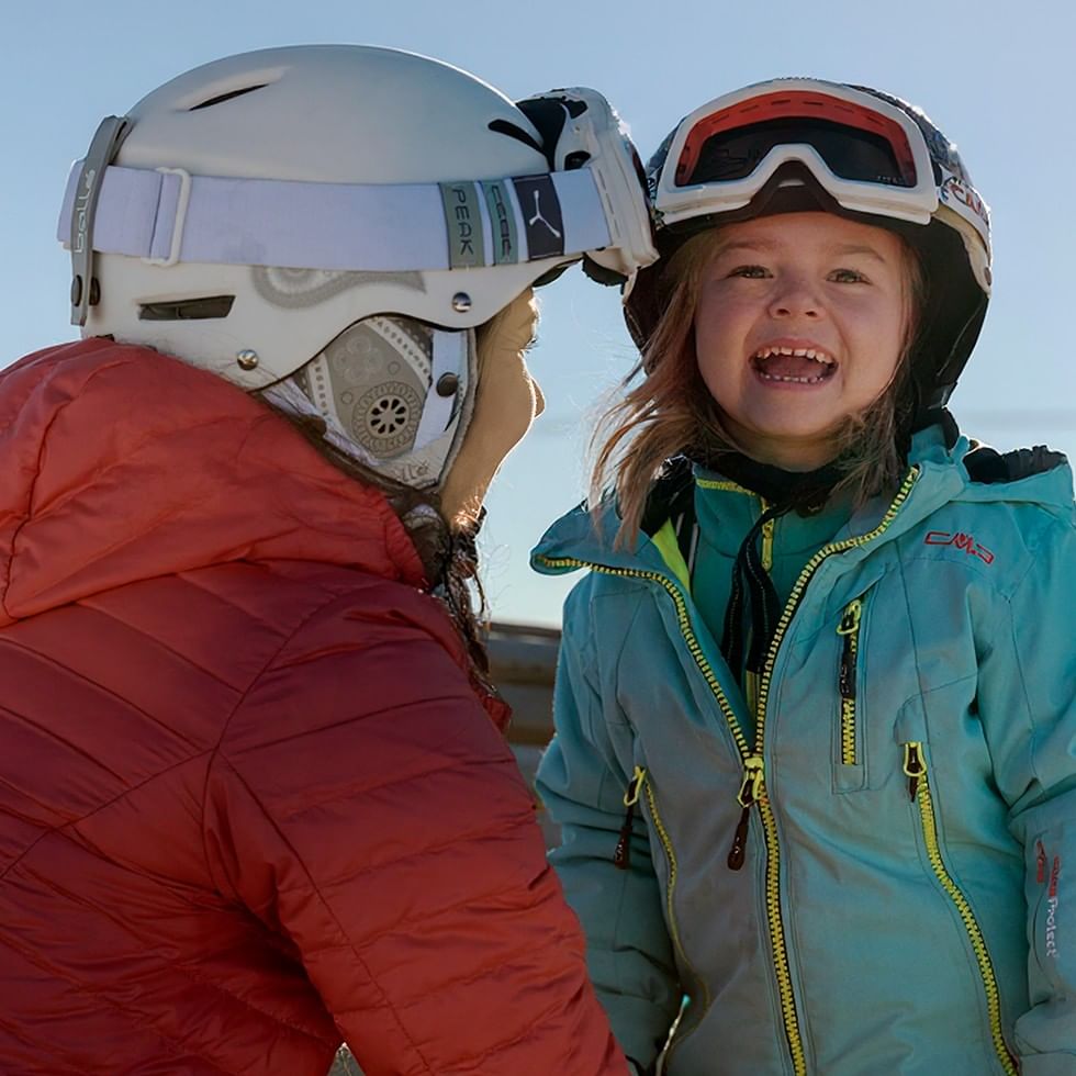 Frau und Mädchen in Skibekleidung und Helmen, März März März.