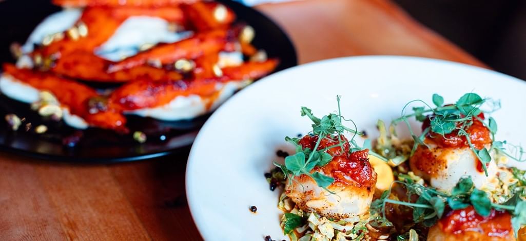 Two plates of delicious food sit on a table at a restaurant in Canmore.