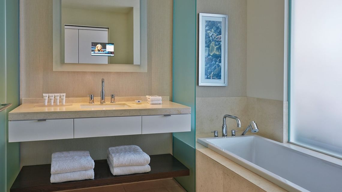 Modern bathroom with sink, tub, and towels