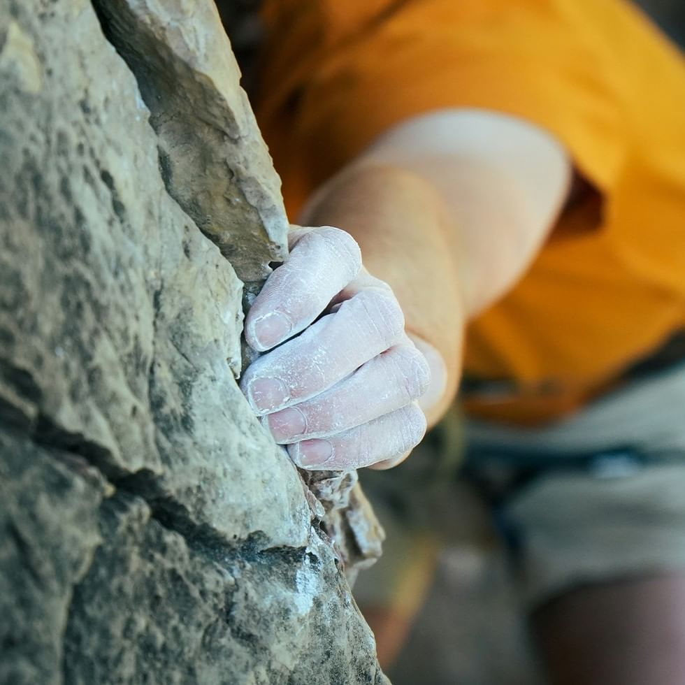 Hand eines Kletterers auf einem Felsen beim Klettersteigschein Ramsau - Jugend.