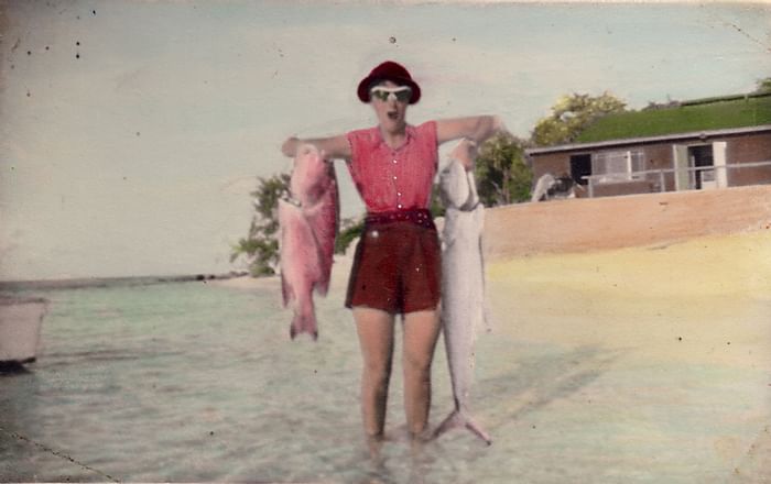 Old photo of a lady holding 2 fish near Heron Island Resort