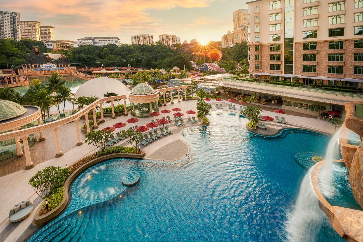 Panoramic sunset view of Sunway Resort’s lively pool area framed by lush greenery and elegant architecture
