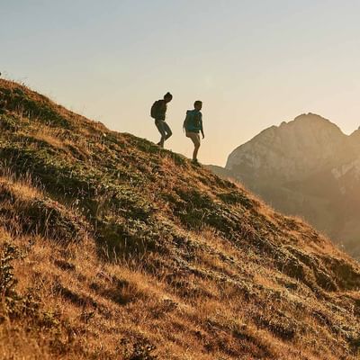 A couple trekking on a hill near Falkensteiner Hotels