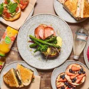 Table set with plates of food and drinks in Little Charley Cafe by Brady Hotels & Apartments