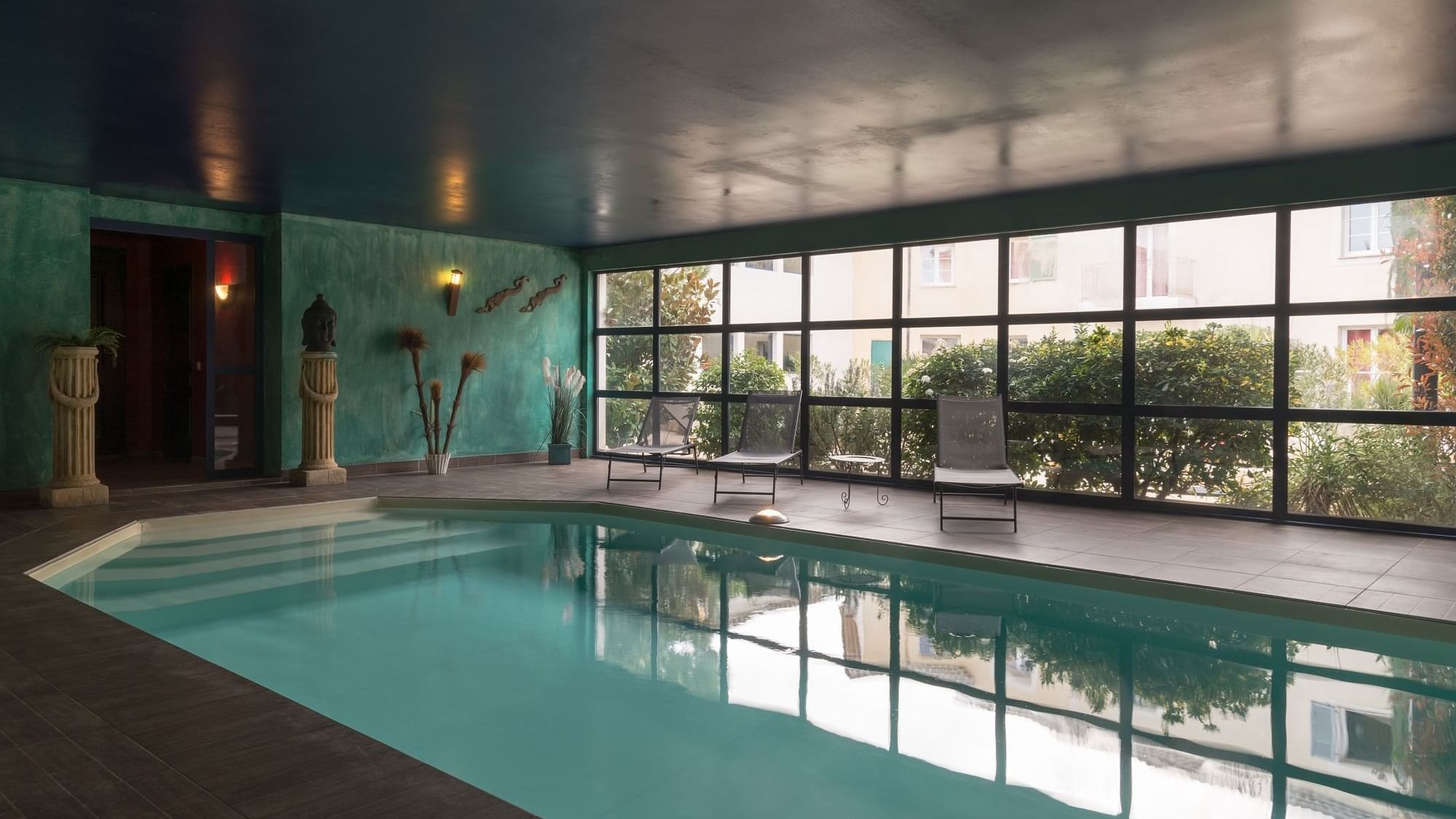 A large indoor pool with a garden view at Originals Hotels