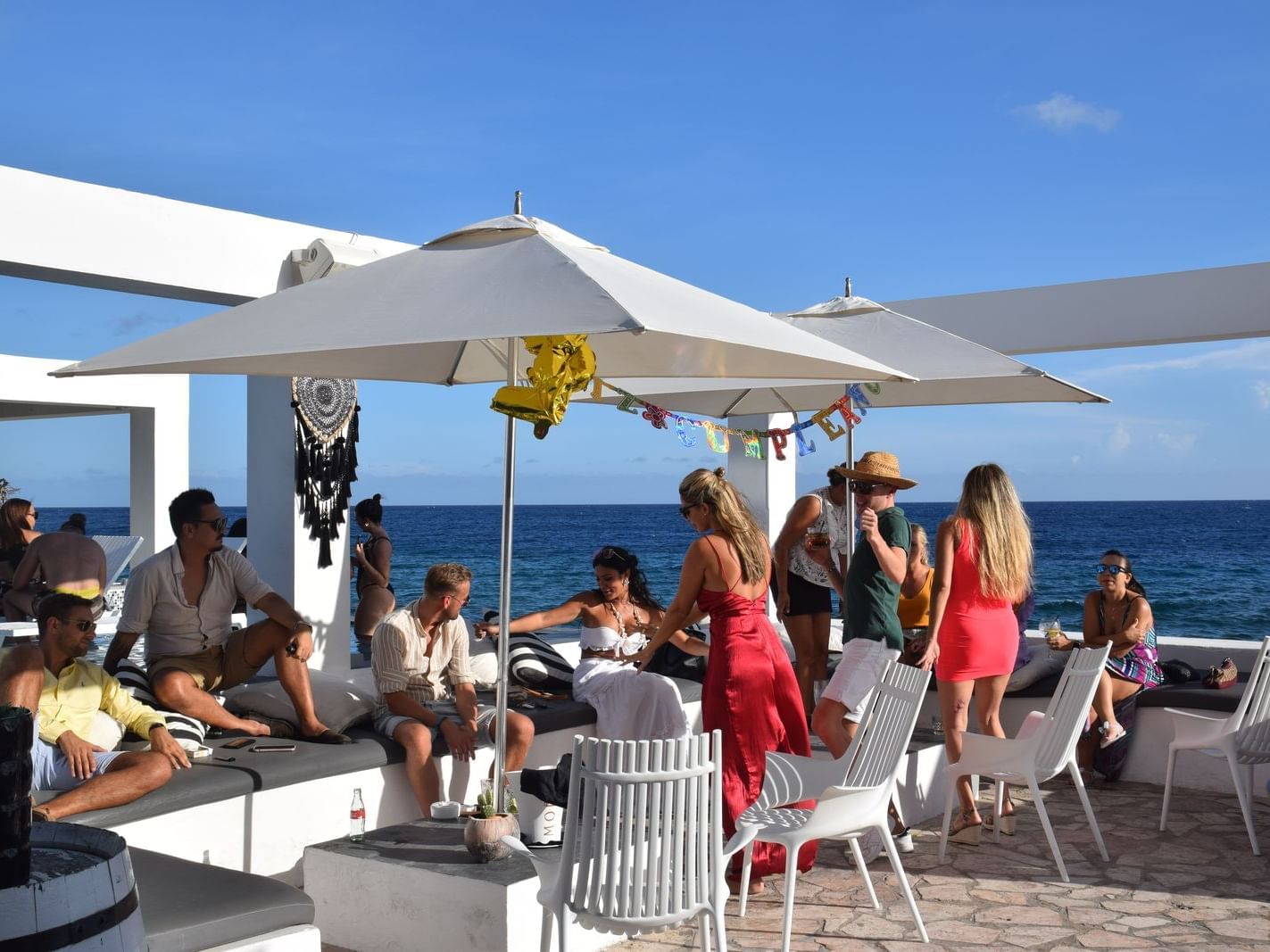 People dancing & drinking on beachfront deck