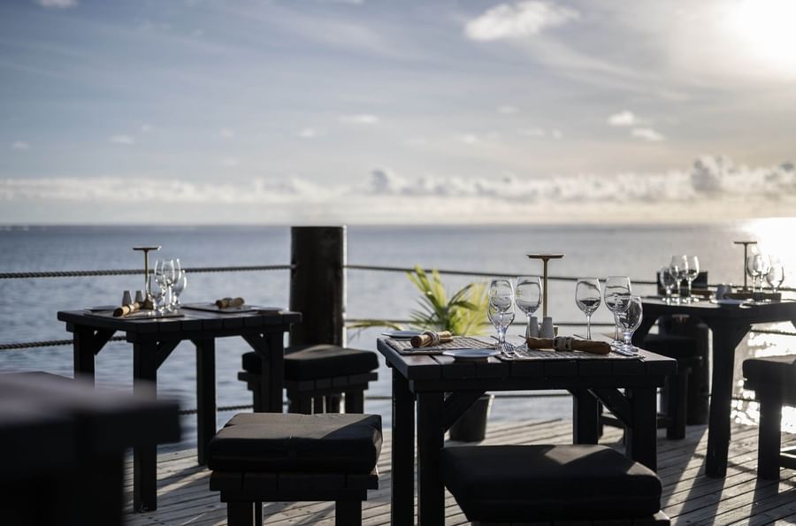 Outdoor tables with wine glasses by a rope railing in Wicked Walu at Warwick Fiji Resort and Spa