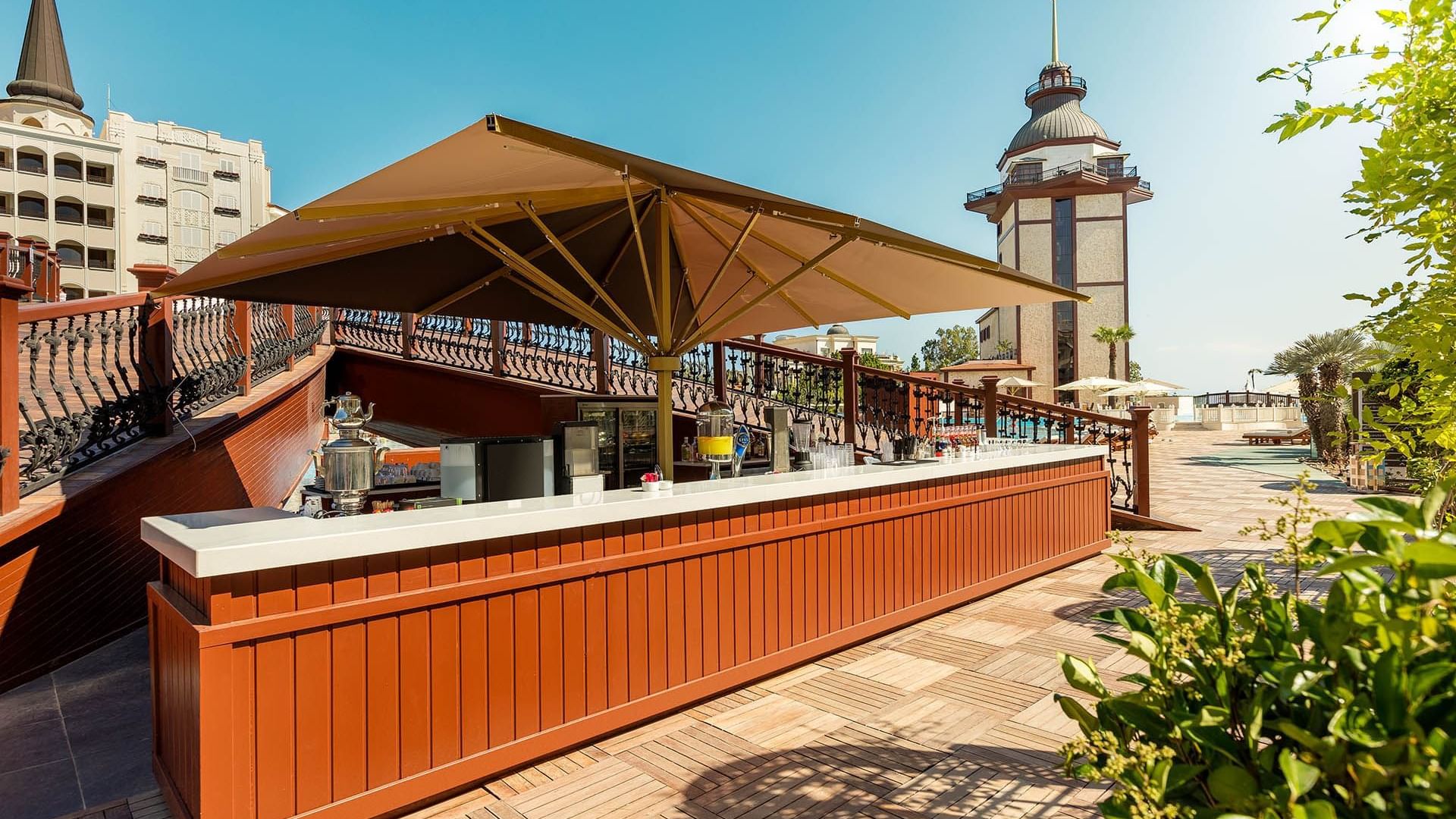 Titanic Mardan Palace’ta Pool Bar, ahşap detaylı açık hava bar alanıyla şık ve rahat bir atmosfer sunar.
