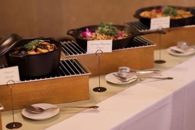 Buffet table with chafing dishes of food and labeled items in The Lodge at Schroon Lake