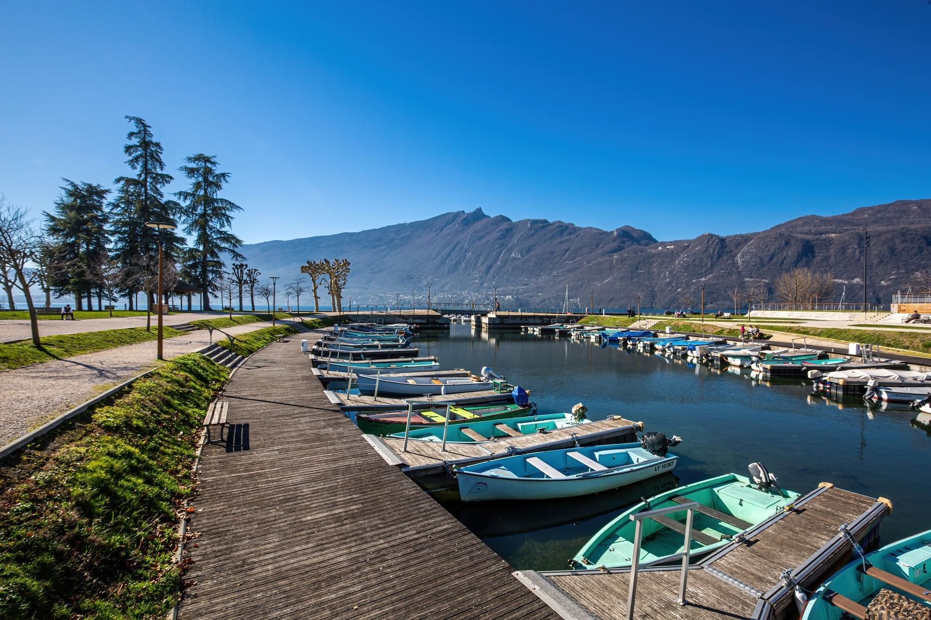 Small boats docked at the port of Aix-les-Bains, surrounded by mountainous terrain near ResidHotel Aix-les-Bains Azurea