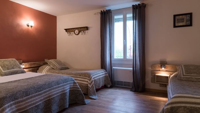 Triple bedroom with open windows at Hotel du parc