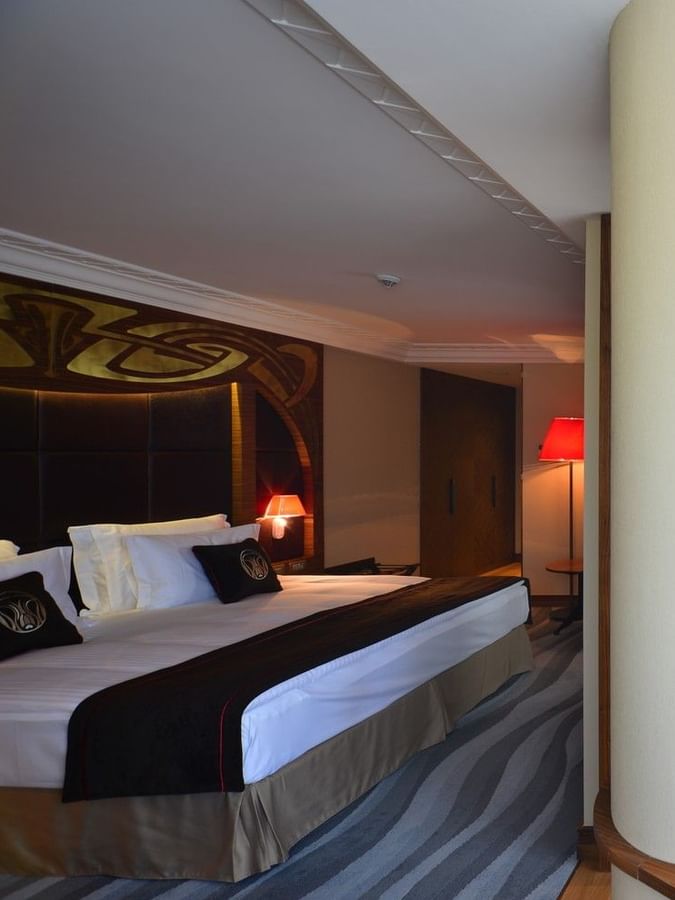 Wooden table by a large pillar under a hanging lampshade in Executive Room at Warwick Ankara