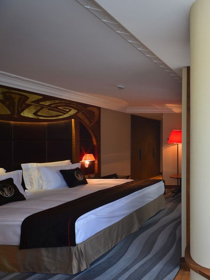 Wooden table by a large pillar under a hanging lampshade in Executive Room at Warwick Ankara