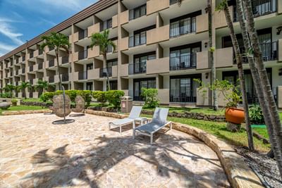 The garden with sun beds and the exterior view of Irazu Hotel