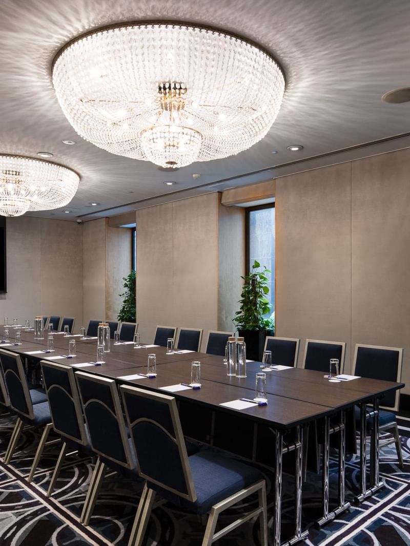 Canberra room boardroom with large conference table, crystal chandeliers and city view windows
