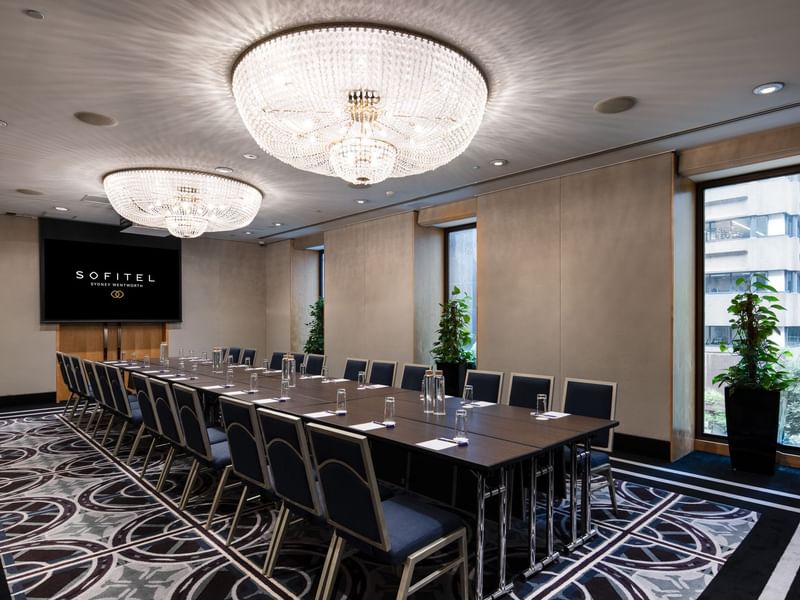 Canberra room boardroom with large conference table, crystal chandeliers and city view windows