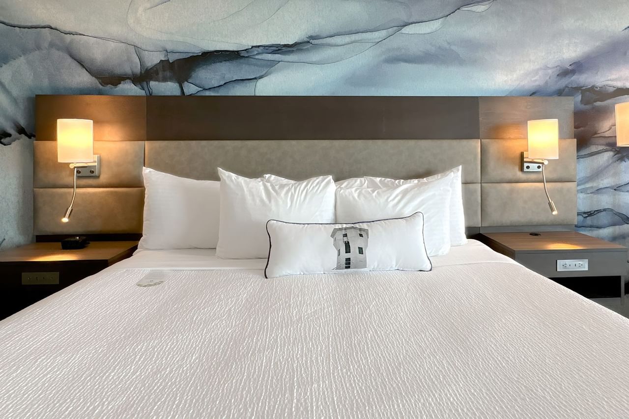 Hotel guestroom with king bed, a nightstands and lights