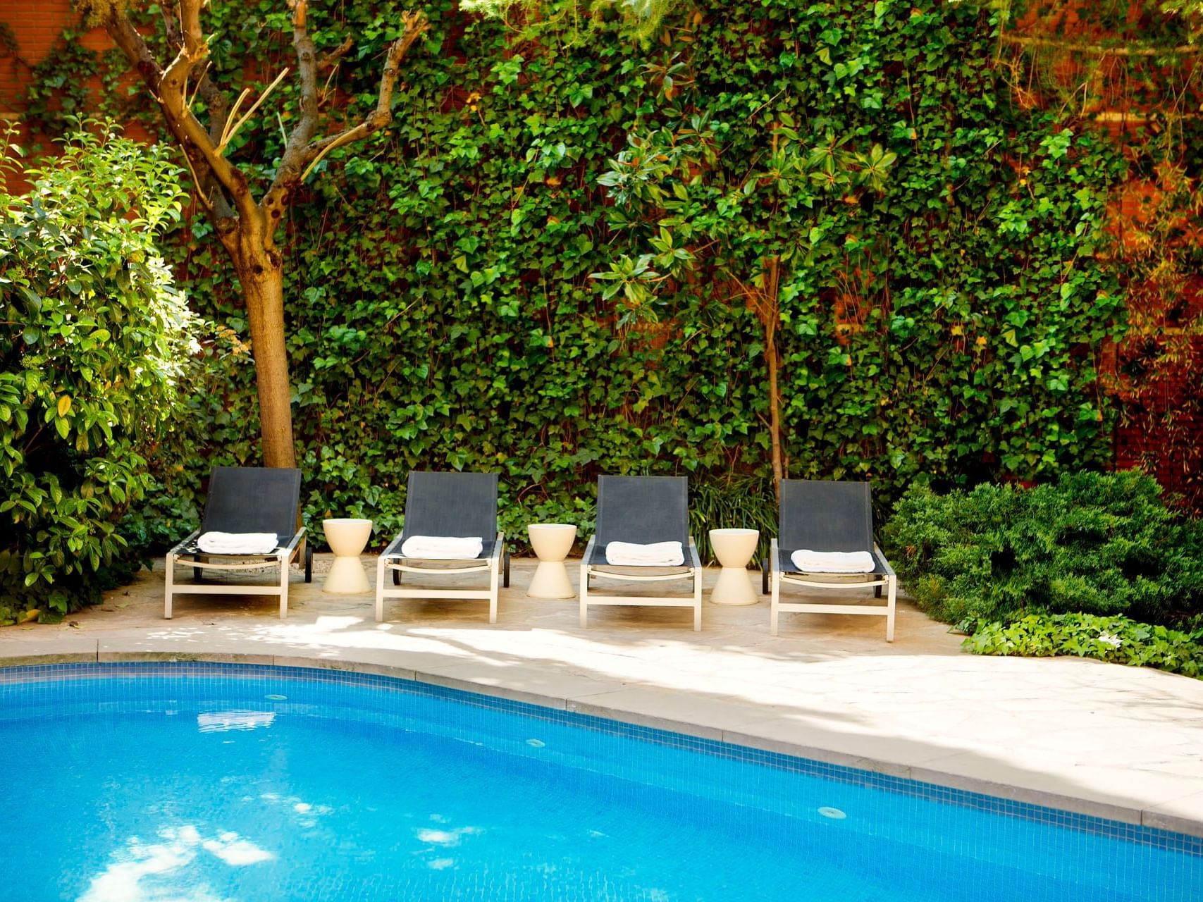 Sunbeds by the outdoor swimming pool at Barcelona Apartment
